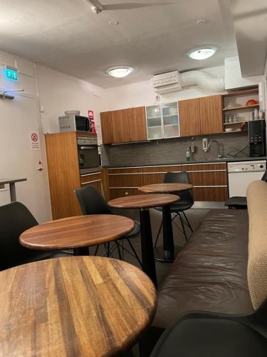 a room with tables and chairs and a kitchen at Uppsala City Hostel in Uppsala