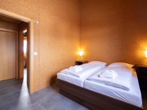 a bedroom with a bed with white sheets and towels at Holiday Home Maiensäss Komfort by Interhome in Urmein
