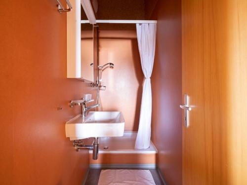 a bathroom with a sink and a shower curtain at Holiday Home Maiensäss Komfort by Interhome in Urmein