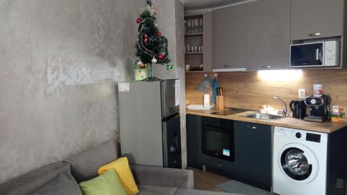 a kitchen with a christmas tree on top of a refrigerator at Студио Еми in Chepelare