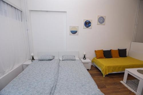 een slaapkamer met 2 bedden en een gele deken bij Central Studio Apartman in Šabac