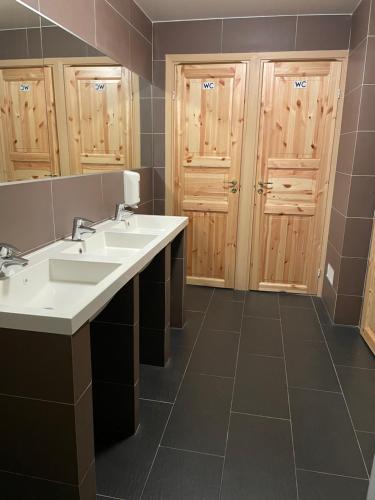 a bathroom with two sinks and two wooden doors at Uppsala City Hostel in Uppsala