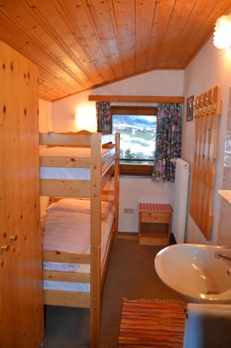 a room with two bunk beds and a sink at Landhaus Buchsteiner in Forstau