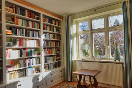 a library with white book shelves filled with books at Stadthaus Rothensande in Schleswig