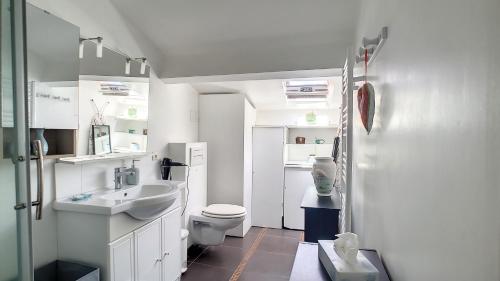 une salle de bain blanche avec des toilettes et un lavabo dans l'établissement SUNNY Duplex classé 3 etoiles climatisé à 2mn à pieds du Port byLaConciergerie13, à La Ciotat