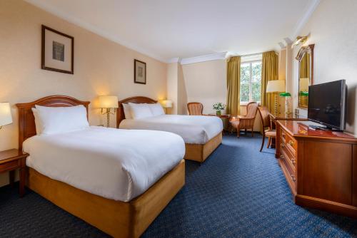 a hotel room with two beds and a flat screen tv at Killarney Plaza Hotel & Spa in Killarney