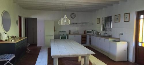 a large kitchen with a wooden table in it at Four Steenbras in Struisbaai