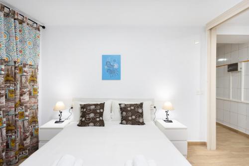 El Rosario的住宿－La Esperanza downtown 3 bd apt，白色卧室配有白色的床和两盏灯。