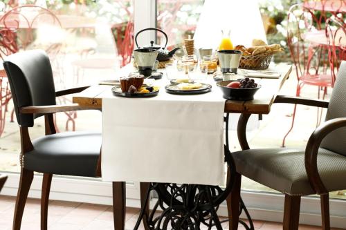 a table with food on it with chairs around it at Auberge Du Paradis in Saint-Amour-Bellevue