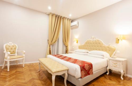 a bedroom with a king sized bed and a chair at Villa Royal in Florence