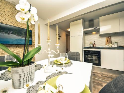 a kitchen and dining room with a table with a white table cloth at Apartment Petra-1 by Interhome in Biograd na Moru