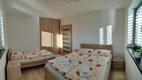 a bedroom with two beds in a room with windows at Villa Alex in Veľká Lomnica