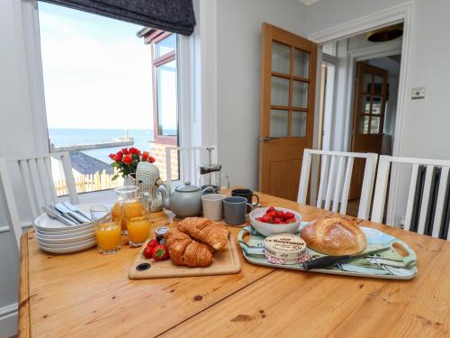 a table with a breakfast of croissants and orange juice at Mariner's Watch in Whitby
