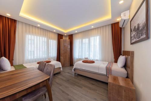 a hotel room with two beds and a table and a desk at Sufra Suite in Istanbul