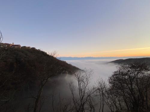 a view of a foggy valley with a hill with trees at Lia's Guest House in Sighnaghi