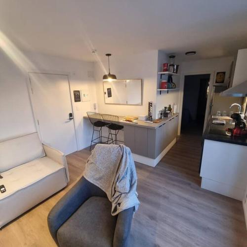 a living room with a couch and a kitchen at EXCLUSIVO PENTHOUSE EN CORDON SOHO CON DISNEY PLUS y PARKING INCLUIDOS in Montevideo
