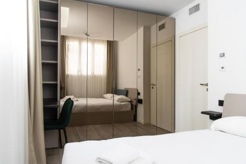 1 dormitorio con 2 camas y espejo en YouHosty - Montebianco 4/6, en Milán
