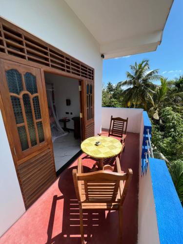 a patio with a table and chairs on a balcony at Resort of Happiness in Mirissa