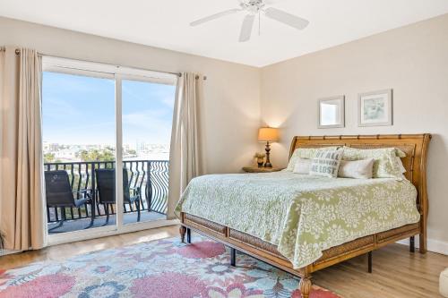 a bedroom with a bed and a balcony at Palms of Treasure Island 405 in St Pete Beach
