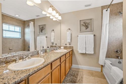 a bathroom with two sinks and a large mirror at Palms of Treasure Island 405 in St Pete Beach