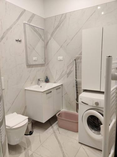 a bathroom with a toilet sink and a washing machine at APARTMENT Dominik **** in Zagreb