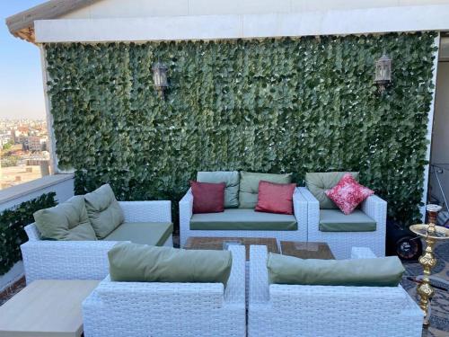 a green wall with couches and pillows on a balcony at The view II in Amman