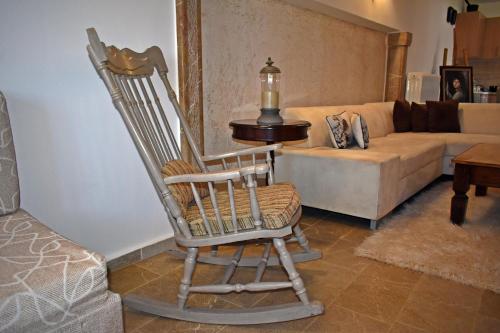 a rocking chair in a living room with a couch at Dimos Suite in Arachova