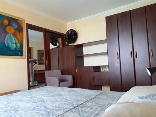 Un dormitorio con una cama, un armario y una silla. en Happy 313 apartamento Frente mar, en Natal