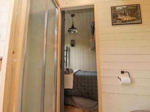 uma porta que leva a um quarto com uma cama em Hillcrest Shepherds Hut em Preston