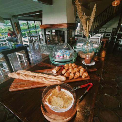 a table with bread and pastries on it at Hôtel & Restaurant La Ferme Du Pommeau in La Plaine des Palmistes