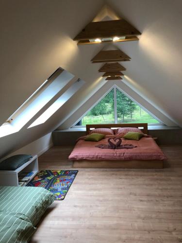 a bedroom with a large bed in a attic at Apartmány Razová - Slezská Harta in Razová