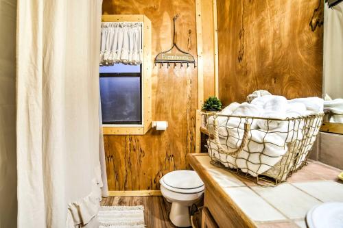 a bathroom with a toilet and a sink and a window at Historic Bruno Hampton Creek Hideaway on 2 Acres in Everton