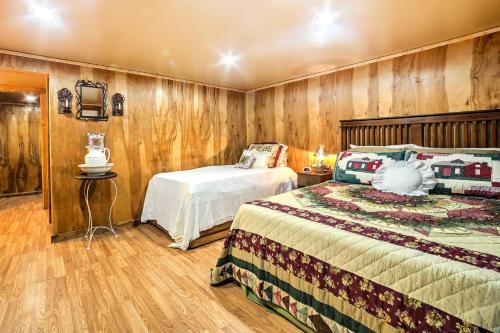 a bedroom with two beds in a room with wooden walls at Historic Bruno Hampton Creek Hideaway on 2 Acres in Everton