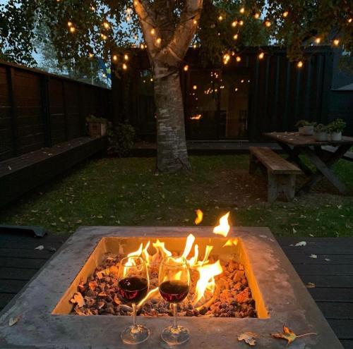 two glasses of wine are next to a fire pit at The Lakeside Motel in Wellington