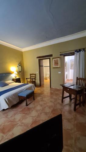 Un dormitorio con una cama y una mesa. en Casa Palacio Conde de Garcinarro en Huete