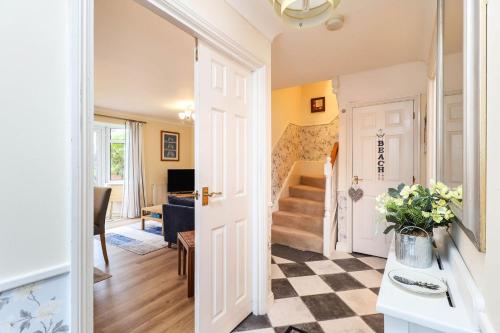a living room with a staircase and a hallway with a door at Hope House in East Cowes
