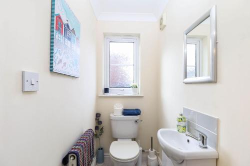 a white bathroom with a toilet and a sink at Hope House in East Cowes