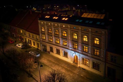 a large building with lights on it at night at Hotel Adler in Byczyna