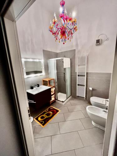a bathroom with a sink and a chandelier at Ca Mimì in centro in Ravenna
