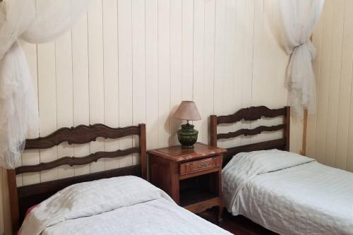 a bedroom with two beds and a table with a lamp at Casa SUPIAVENTO RIO Delta Tigre 8 PREMIUM WIFI in Dique Luján