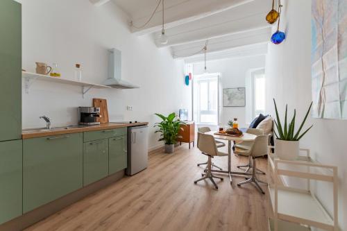 une cuisine avec des placards verts et une table avec des chaises dans l'établissement L'Amarrage, à Marseille