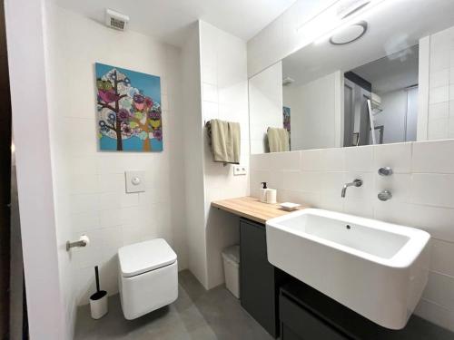 uma casa de banho branca com um lavatório e um WC em Precioso estudio en Barajas, a un paso del Metro em Madrid