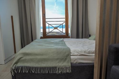 a bedroom with a bed with a view of the ocean at Milmari Apartments Pahulja N Lux in Kopaonik