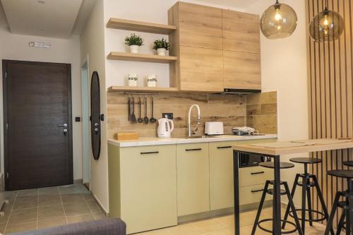 a kitchen with wooden cabinets and a counter with stools at Milmari Apartments Pahulja N Lux in Kopaonik