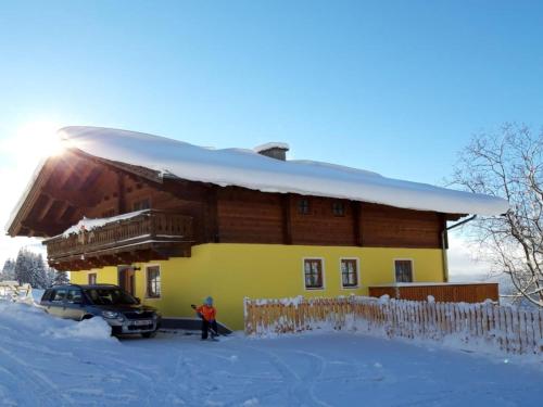 a man standing in front of a house in the snow at Haus Durchegg OG in Wagrain