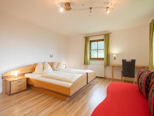 a bedroom with a bed and a red couch at Haus Durchegg OG in Wagrain
