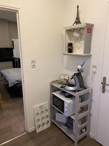 une chambre avec un lit et un four micro-ondes dans l'établissement jolie studio, à Arras