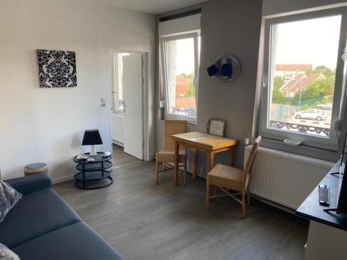 a living room with a blue couch and a table at jolie studio in Arras