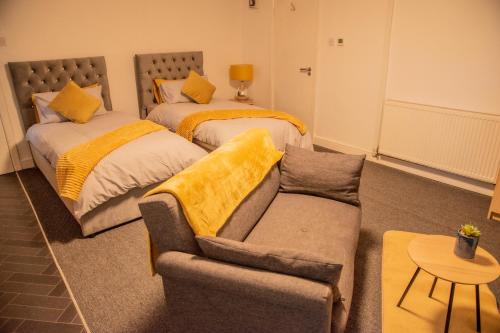 - un salon avec deux lits et un canapé dans l'établissement Bv Comfy Basement 2 At Manningham Bradford, à Bradford