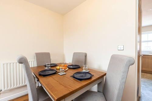 ein Esszimmer mit einem Holztisch und Stühlen in der Unterkunft Cozy Comforts 2 bed apartment Central Warrington in Warrington